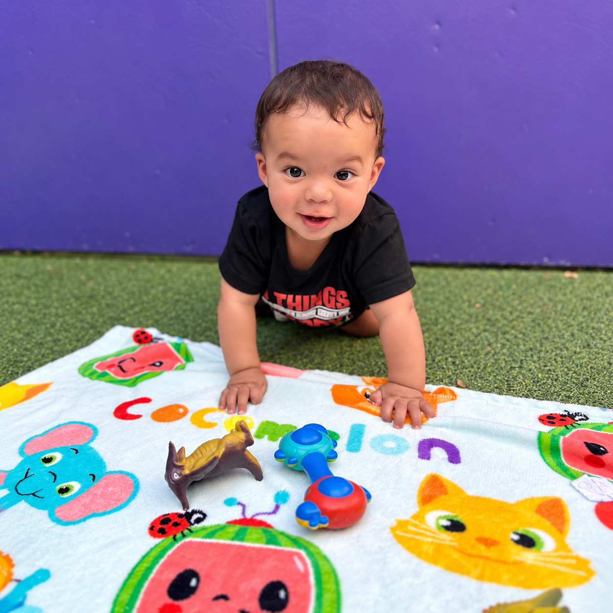 An infant playing with colorful toys during outdoor time at Kidz-Zona